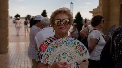 A woman cools off with a fan amid the heat in Cordoba, Spain. AFP