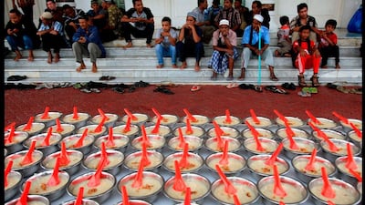 Muslim devotees wait to break their fast as free meals are provided free by a mosque in Banda Aceh, Indonesia on July 16, 2013. Heri Juanda / AP Photo