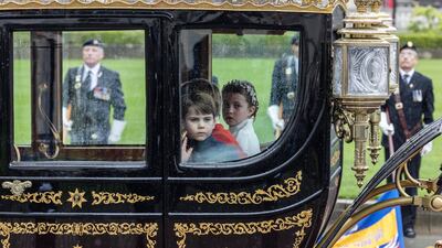 Princess Charlotte, Prince George and Prince Louis sit in a coach as the procession leaves Westminster Abbey following the coronation ceremony of King Charles III and Queen Camilla. AP