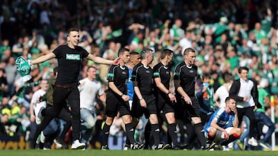 Hibernian fans celebrate on the pitch at the end of the match after winning the Scottish Cup Final as officials walk off. Reuters / Russell Cheyne