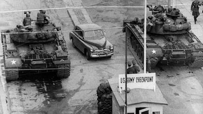 Taken in October of 1961 this image shows a car between US tanks, driving across the famous border of the American sector in Berlin, at Checkpoint Charlie crossing point, the only one in the Berlin Wall between East (Soviet sector) and West Berlin (Americ???