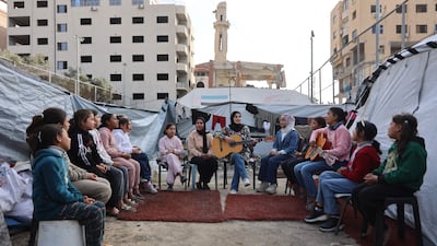 Rula Daloul teaches displaced Palestinian children music and singing among tents at a camp in Gaza city. AFP