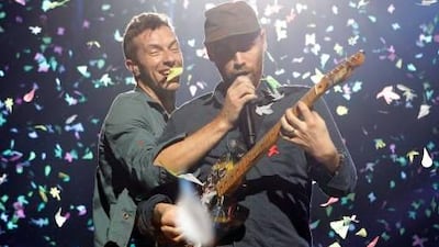Chris Martin and the Coldplay lead guitarist Jonny Buckland onstage in Cologne last week. Roberto Pfeil / AP Photo