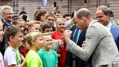Britain's Prince William jokes with children during a tour through the city centre with Heidelberg's Mayor Eckart Wuerzner in Heidelberg. EPA