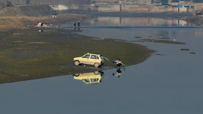 A driver washes his car with water from the Kabul canal, in Peshawar, Pakistan. Reuters