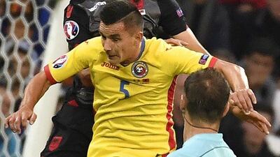 Romania midfielder Ovidiu Hoban, centre, and Albania defender Arlind Ajeti jump for the ball. Jeff Pachoud / AFP