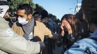 A young protester washes her eyes with Coca-Cola after being pepper sprayed by police in downtown Tunis Tuesday. Erin Clare Brown / The National