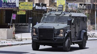 An Israeli armoured vehicle drives through a commercial area in Jenin as a raid on the occupied West Bank city continued on Wednesday. AFP
