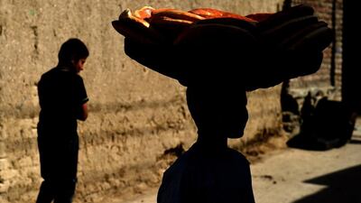 A young boy carries a basket of bread balanced on his head in Kabul, Afghanistan. Farshad Usyan / AFP