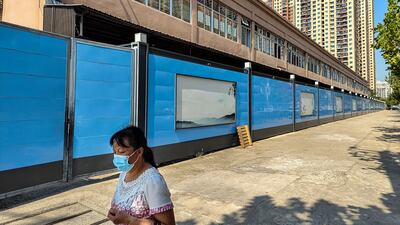 A woman walks past a closed market in Wuhan, the central Chinese city where Covid-19 was first identified. Getty