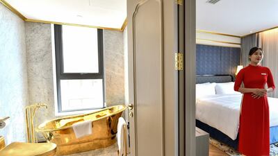 A staff member poses for a photograph inside the $1,000 per night executive two-bedroom suite of Dolce Hanoi Golden Lake hotel. AFP