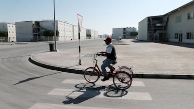 A man rides a bicycle through the accommodation village. Christopher Pike / The National