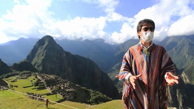 Jean Paul Benavente, Governor of Cusco, talks to experts and authorities assessing the new health and distancing protocols in order to reopen the Inca citadel of Machu Picchu (background) to the public on July 1 during a visit to the ruin grounds on June 12, 2020. AFP