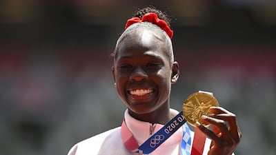Athing Mu, of the United States, celebrates on the podium with the gold medal after competing in the women's 800m final.
