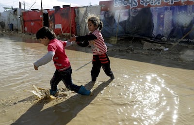 Children wade through floodwaters at their camp in Bekaa Valley, Lebanon. Joseph Eid / AFP