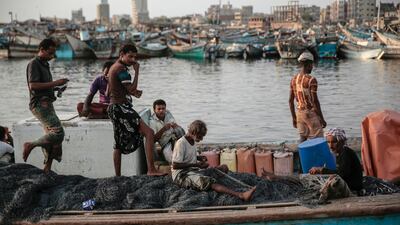 In this Sept. 29, 2018, photo, 71 year-old Yemeni fisherman Ammar Ahmed, center, prepares his net before a fishing trip at the main fishing port, in Hodeida, Yemen. (AP Photo/Hani Mohammed)