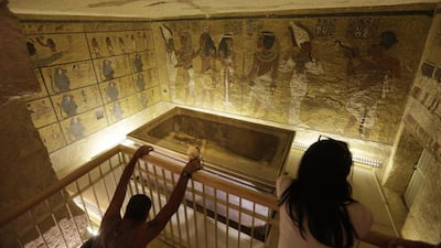 A file photo of tourists looking at the tomb of King Tut as it is displayed in a glass case at the Valley of the Kings in Luxor. Egypt's antiquities minister Mamdouh El Damaty, said on March 17, 2016, that analysis of scans of the famed king's burial chamber has revealed two hidden rooms that could contain metal or organic material. Amr Nabil/AP Photo