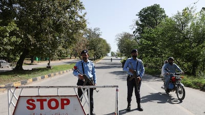 Pakistani police guard a road in Islamabad, where the US and Iran are to hold talks. Reuters