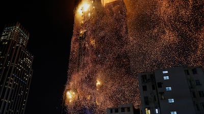 Sparks rain down on neighbouring streets as flames engulf the high-rise building in popular shopping district of Tsim Sha Tsui, in Hong Kong. Reuters