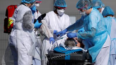 French rescue team wearing protective suits carry a patient on a stretcher from Mulhouse hospital. Reuters
