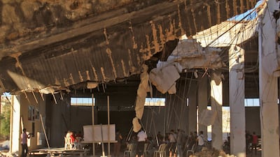 Syrians gather on July 12, 2017 at a destroyed building in Khan Sheikhun 100 days following a suspected toxic gas attack that was reported to have killed 88 people, including 31 children. AFP / Omar haj kadour