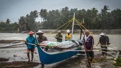 Fishermen carry a boat to higher ground in Baybay, eastern Samar after typhoon Phanfone hit the central Philippines. AFP
