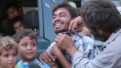 A man cuts the beard of a civilian who was evacuated from Manbij, in Aleppo Governorate, Syria,. Rodi Said / Reuters