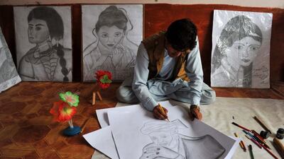 Afghan artist Maroof, 23, draws a picture of outgoing Afghan President Hamid Karzai to be sold in his shop in Jalalabad on April 24. Afghanistan's third presidential election brings an end to 13 years of rule by Karzai, who has held power since the Taliban were removed in a US-led invasion in 2001, and will be the first democratic handover of power in the country's turbulent history. Noorullah Shirzada / AFP Photo