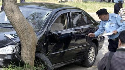 A Pakistani police officer examines a car of Pakistan religious affairs minister Hamid Saeed Kazmi after he was attacked by gunmen in Islamabad, Pakistan, on Wednesday, September 2, 2009.