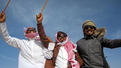 Men dance in the back of a 4x4 to celebrate Mahueba the camel, a four-year-old beauty contestant at the Al Dhafra festival in Abu Dhabi. (Anna Zacharias / The National / December 2013)