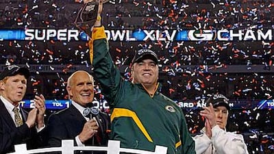 Green Bay Packers head coach Mike McCarthy holds up the Vince Lombardi Trophy.