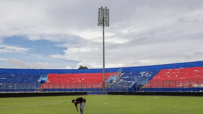 An Arema FC player he pays condolence on the pitch to victims of the soccer match riot and stampede at Kanjuruhan Stadium in Malang, East Java, Indonesia, on October 3. EPA