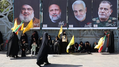 Iranian women near banners of (L-R) Hezbollah leader Hasan Nasrallah, Iran's deceased former president Ebrahim Raisi, and the IRGC's late Qassem Soleimani and Abbas Nilforoushan during an anti-Israeli rally on October 2. EPA