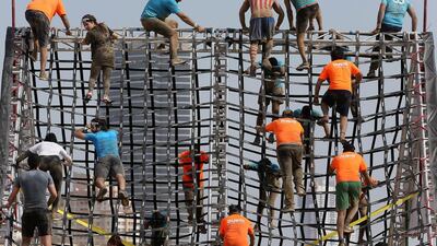 People clumb up and down the A frame obstacle.
