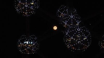 The harvest moon, the fourth and final supermoon of 2023, rises over the Atomium monument in Brussels, Belgium. AFP