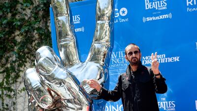 Ringo Starr mimics a peace sign statue during a 77th birthday celebration for the former Beatle at Capitol Records on Friday, July 7 in Los Angeles. Courtesy Chris Pizzello/Invision/AP