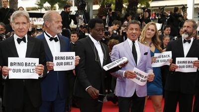 The cast of The Expendables 3, from left, Kelsey Grammer, Wesley Snipes, Sylvester Stallone, Ronda Rousey and Mel Gibson hold up banners reading, Bring Back Our Girls, part of a campaign calling for the release of nearly 300 abducted Nigerian schoolgirls being held by Nigerian Islamic extremist group Boko Haram, as they arrive for the screening of The Homesman at the 67th international film festival in Cannes, France on May 18, 2014. Alastair Grant / AP photo