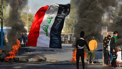 A protester waves the Iraqi flag during an anti-government demonstration in Najaf. AFP