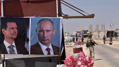 Russian and Syrian forces stand guard near posters of presidents Vladimir Putin and Bashar Al Assad at the Abu Duhur crossing on the eastern edge of Idlib province / AFP