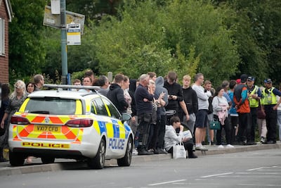 Police talk to people outside Tewkesbury Academy, Gloucesteshire, England, where a teenage boy was arrested after a stabbing on July 10. Getty