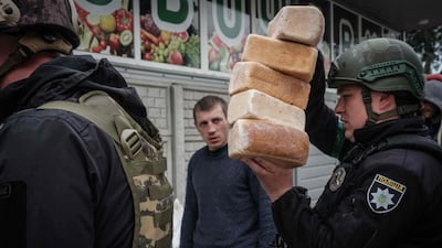 Police officers deliver loaves of bread to residents in the eastern Ukrainian city of Lyman, which is being heavily shelled. AFP