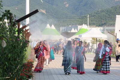 Attendees at the World Scout Jamboree walk through a mist sprays to cool off at a campsite in Buan. AP