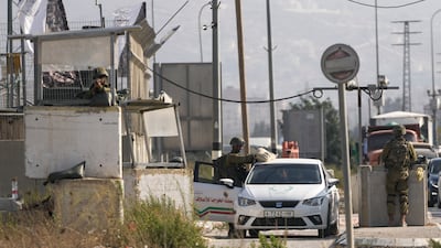 Israeli soldiers check a Palestinian car at the Hawara checkpoint in the occupied West Bank on Saturday after two Israelis were shot dead in the town. AP Photo
