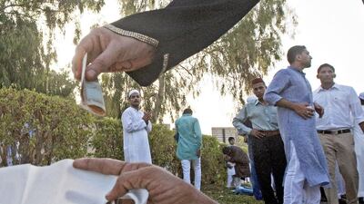 A woman donates money to a beggar outside a prayer area in Al Baraha, Dubai. Police say that only by giving through the recognised charitable organisations can residents be sure their zakat is going to a good cause. Jeff Topping / The National