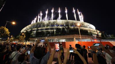 People gather near the National Stadium to watch the fireworks during the closing ceremony of the Tokyo Olympics.