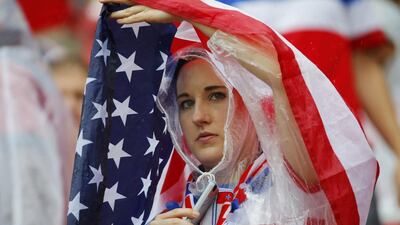 A fan of the United States drapes the national flag over herself as it rains before their 2014 World Cup Group G match against Germany on Thursday in Recife, Brazil. Laszlo Balogh / Reuters
