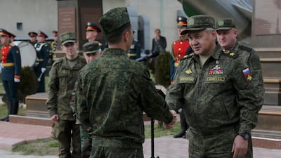 Mr Shoigu, right, visits Russia's Hmeimim airbase, south-east of the city of Latakia, in Syria. EPA