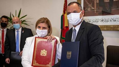 Ryad Mezzour, Morocco's Industry and Trade Minister, shakes hands with Orna Barbivai, Israel's Economy Minister after signing a trade agreement between the two countries in Rabat. AFP