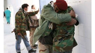 Three rebel fighters grieve for their friend Ibrahim el Felah at Ajdabiyah hospital after he accidentally shot himself dead.
