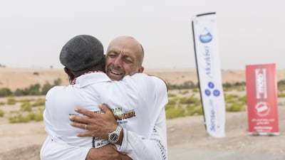 Max Calderan receives a hug of congratulations from a member of his support team after finishing his 340km trek. Courtesy Mauro Grigollo